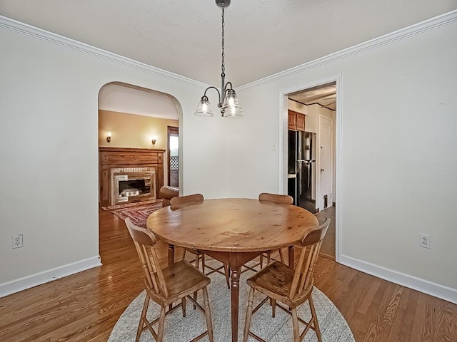 1907 Shaler Dr, Shaler, PA 15116 - dining room featuring arched walkways, light wood finished floors, crown molding, and a glass covered fireplace