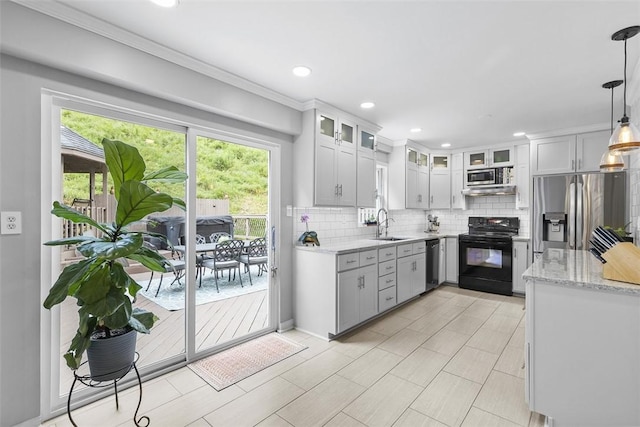 108 Oak Pointe Dr, Monroeville, PA 15146 - kitchen featuring appliances with stainless steel finishes, backsplash, light stone countertops, glass insert cabinets, and decorative light fixtures