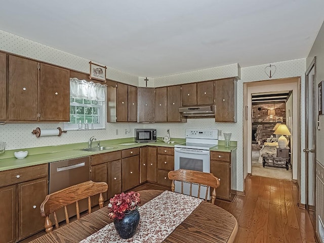 141 Clover Ln, Pine Twp, PA 15044 - kitchen with wallpapered walls, under cabinet range hood, white electric range oven, wood finished floors, and stainless steel dishwasher