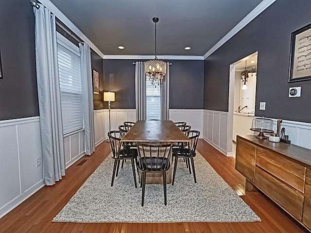 410 Bailey Ave, Mt Washington, PA 15211 - dining area with a wainscoted wall, a chandelier, wood finished floors, crown molding, and a decorative wall