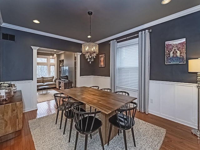 410 Bailey Ave, Mt Washington, PA 15211 - dining area with decorative columns, a wainscoted wall, crown molding, hardwood / wood-style flooring, and a decorative wall