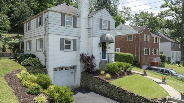 1155 Cedar Blvd, Mt Lebanon, PA 15228 - view of front of home featuring an attached garage, a chimney, a front lawn, and asphalt driveway