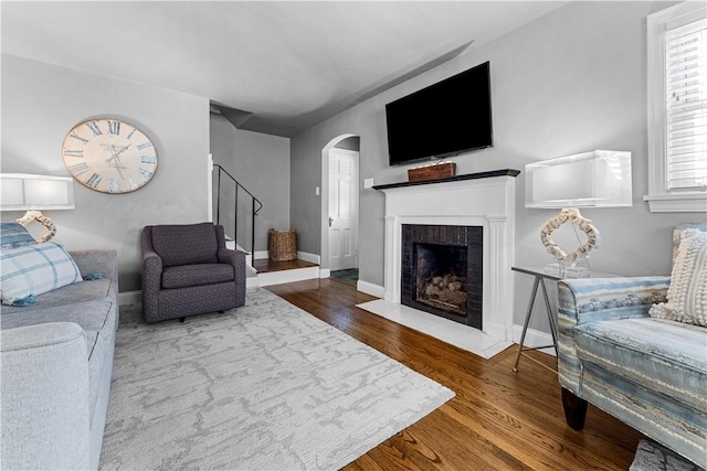1155 Cedar Blvd, Mt Lebanon, PA 15228 - living area featuring stairs, a fireplace with flush hearth, arched walkways, and wood finished floors