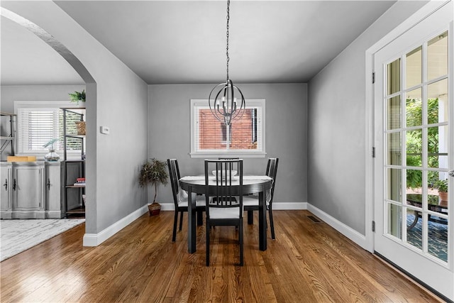 1155 Cedar Blvd, Mt Lebanon, PA 15228 - dining area with arched walkways, a chandelier, and wood finished floors