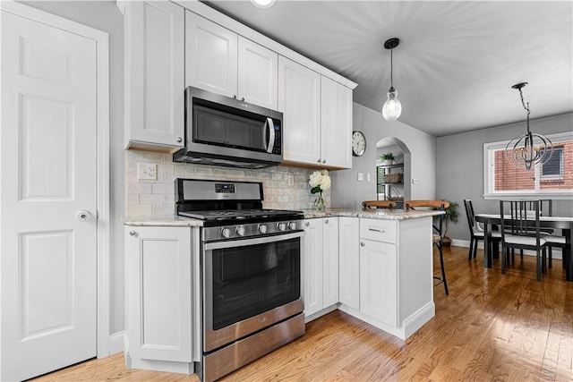 1155 Cedar Blvd, Mt Lebanon, PA 15228 - kitchen featuring stainless steel appliances, a peninsula, light wood-style flooring, tasteful backsplash, and white cabinets