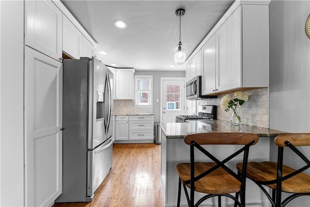 1155 Cedar Blvd, Mt Lebanon, PA 15228 - kitchen with stainless steel appliances, a peninsula, white cabinetry, recessed lighting, and a breakfast bar