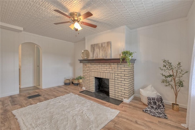 881 Main St, North Huntingdon, PA 15642 - living area featuring arched walkways, wood finished floors, a ceiling fan, and a brick fireplace