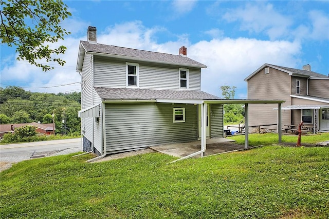 881 Main St, North Huntingdon, PA 15642 - back of house featuring a lawn, a chimney, and a patio
