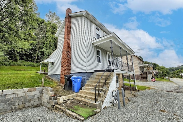 881 Main St, North Huntingdon, PA 15642 - view of front of property with stairs, a chimney, a front lawn, and a porch