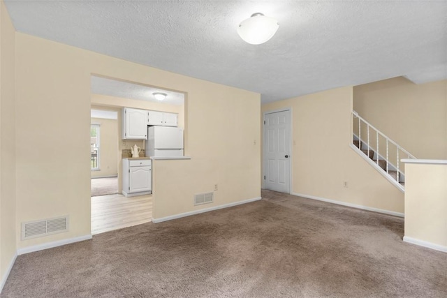 3080 E Bardonner Rd, Hampton, PA 15044 - unfurnished living room with light colored carpet, a textured ceiling, and stairway