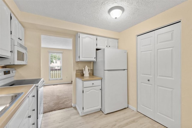 3080 E Bardonner Rd, Hampton, PA 15044 - kitchen with white appliances, a textured ceiling, light wood-type flooring, white cabinetry, and light countertops