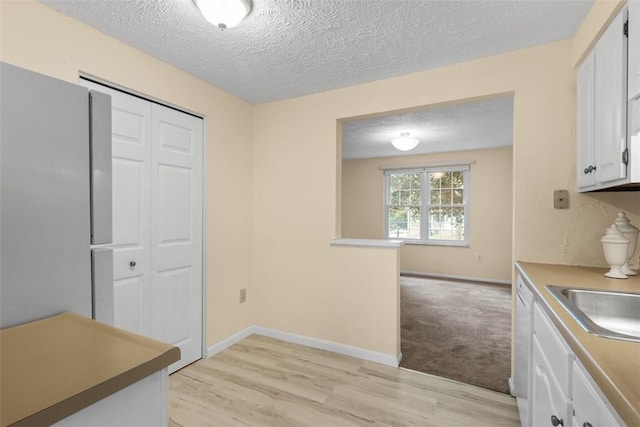 3080 E Bardonner Rd, Hampton, PA 15044 - kitchen featuring white cabinets, light wood-style flooring, a textured ceiling, and white dishwasher