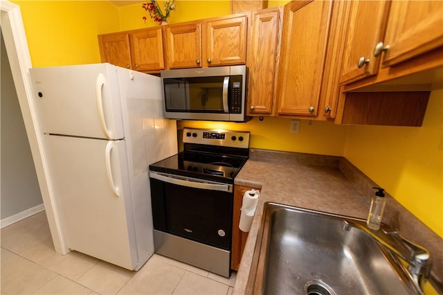 425 N Neville St Unit 302, Oakland, PA 15213 - kitchen with stainless steel appliances, light tile patterned flooring, and brown cabinets