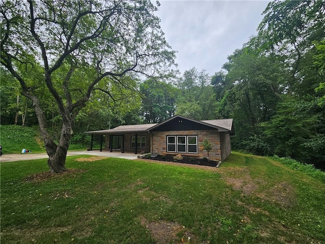352 Hartzell School Rd, Marion Twp, PA 16123 - single story home featuring stone siding, a front yard, concrete driveway, a view of trees, and a carport