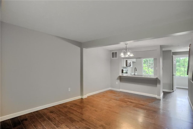 7311 Lafayette Sq, Hopewell Twp, PA 15001 - unfurnished living room featuring a chandelier and dark wood-style flooring