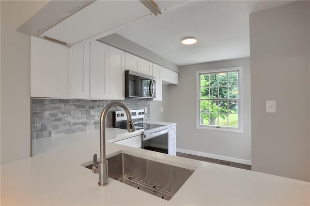 7311 Lafayette Sq, Hopewell Twp, PA 15001 - kitchen featuring stainless steel microwave, white electric range oven, backsplash, and white cabinets