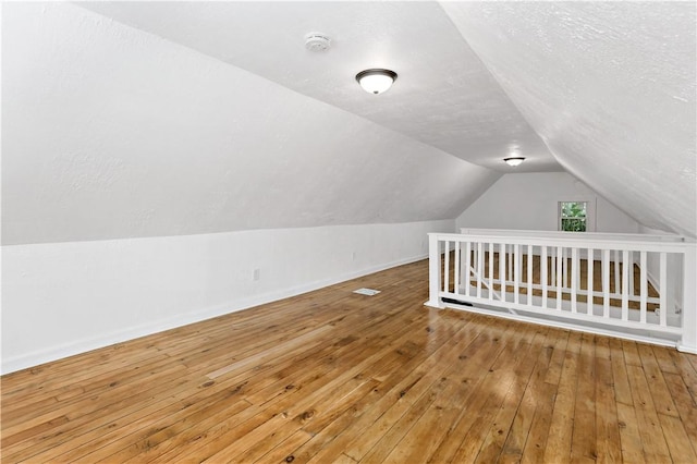 428 Card Ave, Wilmerding, PA 15148 - additional living space with vaulted ceiling, hardwood / wood-style floors, and a textured ceiling