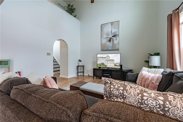 811 Sunset Cir Unit 811, Cranberry Twp, PA 16066 - living room with arched walkways, wood finished floors, stairs, and a towering ceiling