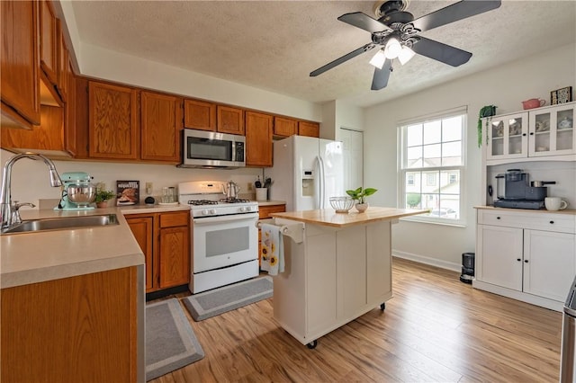 811 Sunset Cir Unit 811, Cranberry Twp, PA 16066 - kitchen featuring white appliances, light countertops, light wood-type flooring, a textured ceiling, and brown cabinets