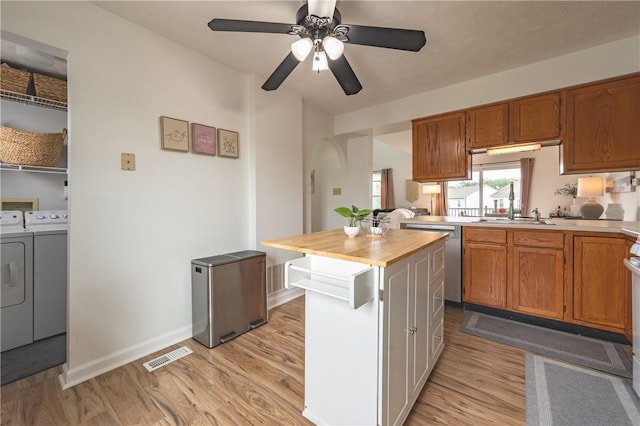 811 Sunset Cir Unit 811, Cranberry Twp, PA 16066 - kitchen with independent washer and dryer, light wood-style floors, dishwasher, arched walkways, and a kitchen island