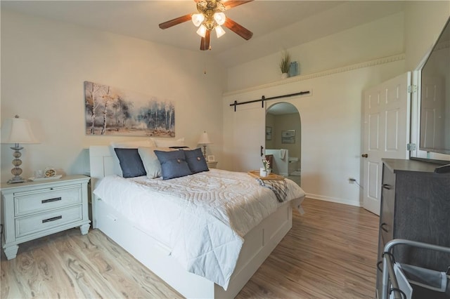 811 Sunset Cir Unit 811, Cranberry Twp, PA 16066 - bedroom with light wood finished floors, a barn door, arched walkways, and lofted ceiling
