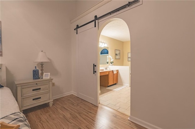 811 Sunset Cir Unit 811, Cranberry Twp, PA 16066 - bedroom with arched walkways, wood finished floors, connected bathroom, and a barn door