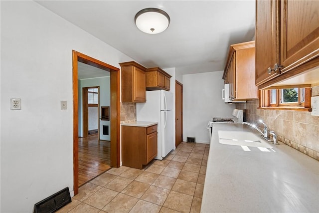 512 Alexander Ave, Southwest Greensburg, PA 15601 - kitchen with white appliances, light countertops, backsplash, brown cabinetry, and light tile patterned floors