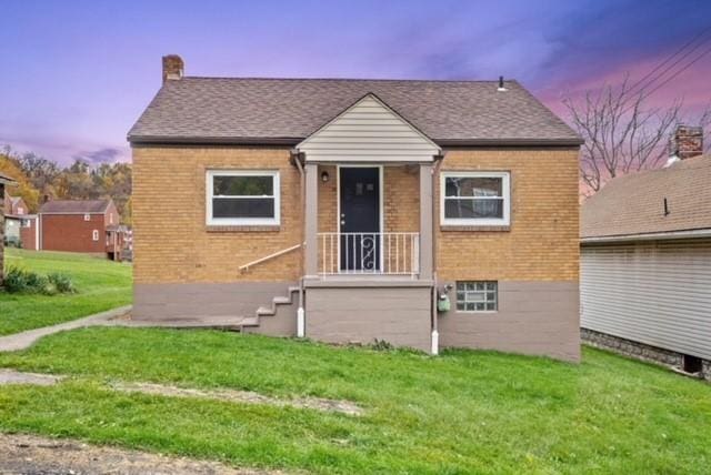 444 27th St, Mckeesport, PA 15132 - bungalow-style house featuring brick siding, a front lawn, a chimney, and roof with shingles