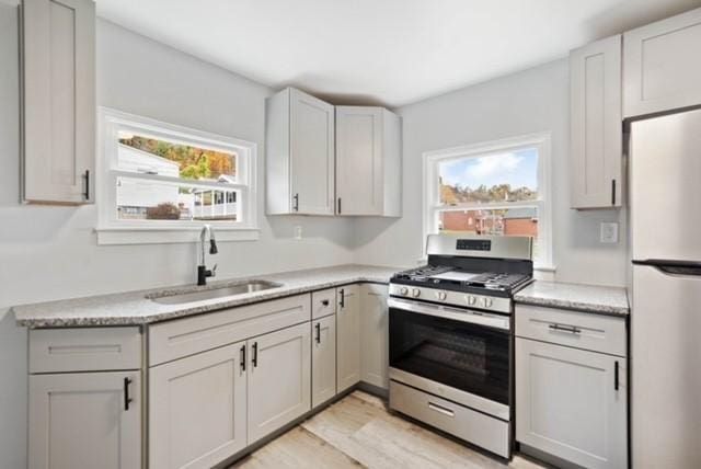 444 27th St, Mckeesport, PA 15132 - kitchen with freestanding refrigerator, stainless steel range with gas cooktop, plenty of natural light, and light wood-style flooring