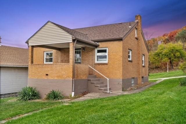 444 27th St, Mckeesport, PA 15132 - back of property at dusk with brick siding, a chimney, and a lawn