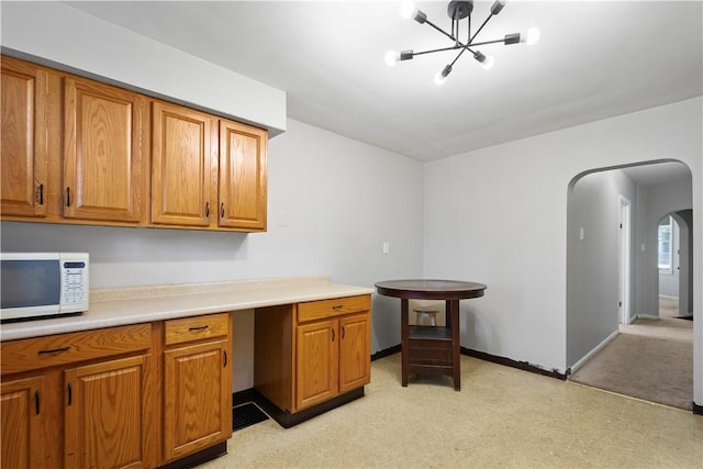 625 N Main St, City Of Washington, PA 15301 - kitchen featuring white microwave, arched walkways, brown cabinets, a chandelier, and light countertops