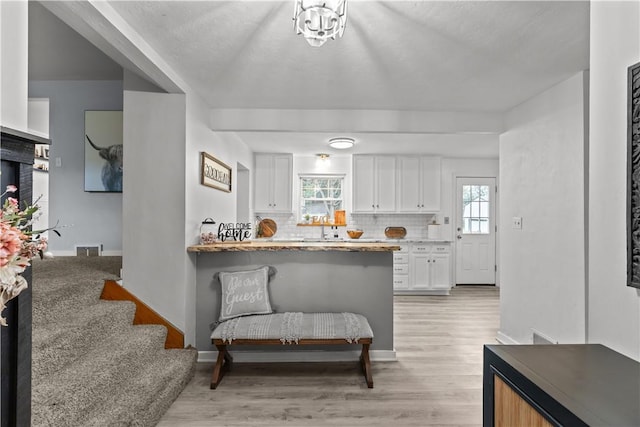 217 Westmont Rd, Ross Twp, PA 15237 - kitchen featuring white cabinetry, healthy amount of natural light, decorative backsplash, and light wood-type flooring