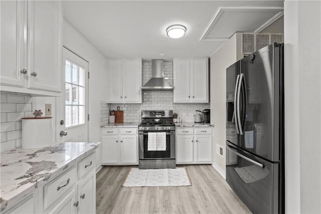 217 Westmont Rd, Ross Twp, PA 15237 - kitchen with refrigerator with ice dispenser, stainless steel range with gas cooktop, wall chimney exhaust hood, and light wood-style flooring