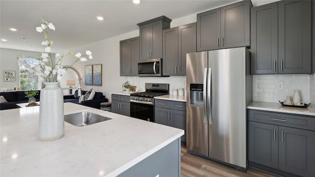 527 Cooper St Unit 3, Mccandless, PA 15090 - kitchen with appliances with stainless steel finishes, light wood finished floors, decorative backsplash, recessed lighting, and open floor plan