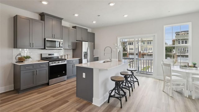 527 Cooper St Unit 3, Mccandless, PA 15090 - kitchen featuring stainless steel appliances, gray cabinetry, light wood finished floors, a kitchen bar, and recessed lighting