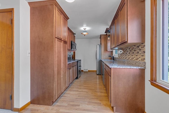 105 Eakin Dr, Brighton Twp, PA 15009 - kitchen with stainless steel appliances, light wood-style flooring, decorative backsplash, brown cabinetry, and light stone countertops