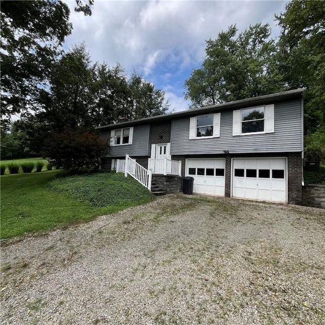 503 Bagdad Rd, Allegheny Twp, PA 15656 - bi-level home with a garage, gravel driveway, brick siding, and a front yard