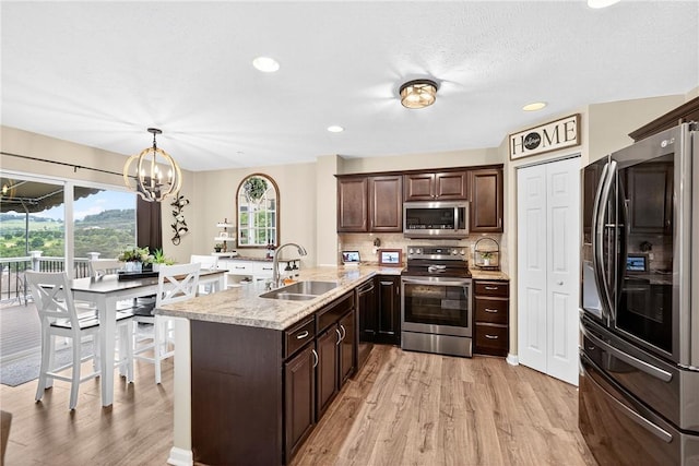 2000 Moccasin Dr, South Strabane, PA 15301 - kitchen with appliances with stainless steel finishes, dark brown cabinets, a peninsula, light wood-style floors, and recessed lighting