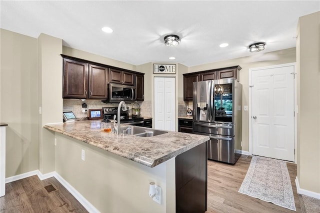 2000 Moccasin Dr, South Strabane, PA 15301 - kitchen featuring stainless steel appliances, dark brown cabinetry, light wood-style floors, tasteful backsplash, and recessed lighting