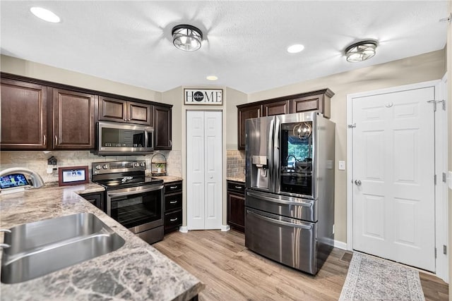 2000 Moccasin Dr, South Strabane, PA 15301 - kitchen featuring appliances with stainless steel finishes, dark brown cabinetry, light wood-style flooring, decorative backsplash, and recessed lighting