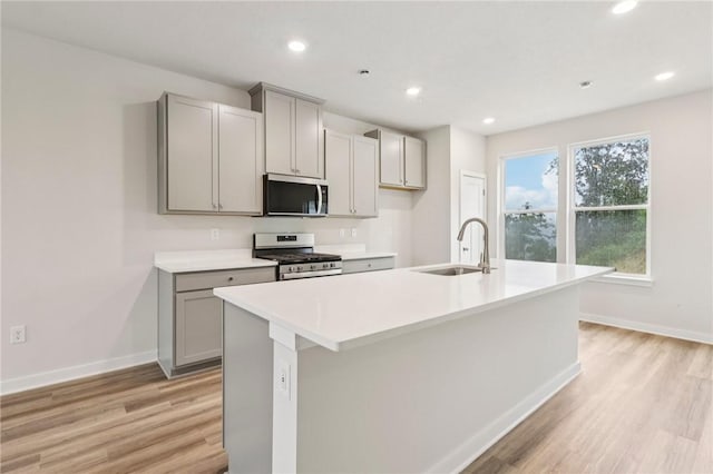 118 River Ridge Drive, Moon/Crescent Twp, PA 15108 - kitchen featuring stainless steel appliances, gray cabinetry, light wood finished floors, a center island with sink, and recessed lighting