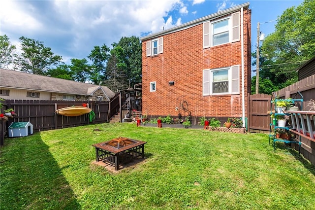 1029 3rd St, Baden, PA 15005 - back of house featuring a fire pit, brick siding, and a fenced backyard