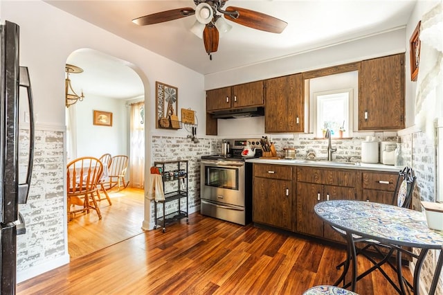 1029 3rd St, Baden, PA 15005 - kitchen with stainless steel electric range, under cabinet range hood, ceiling fan, light countertops, and arched walkways