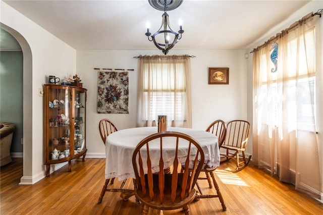 1029 3rd St, Baden, PA 15005 - dining space with arched walkways, light wood-style flooring, and a chandelier