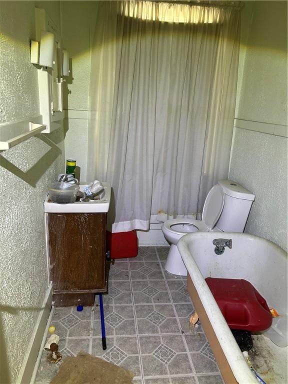 15 E Gaskill Ave, Jeannette, PA 15644 - full bathroom featuring a soaking tub, vanity, a textured wall, and tile patterned flooring