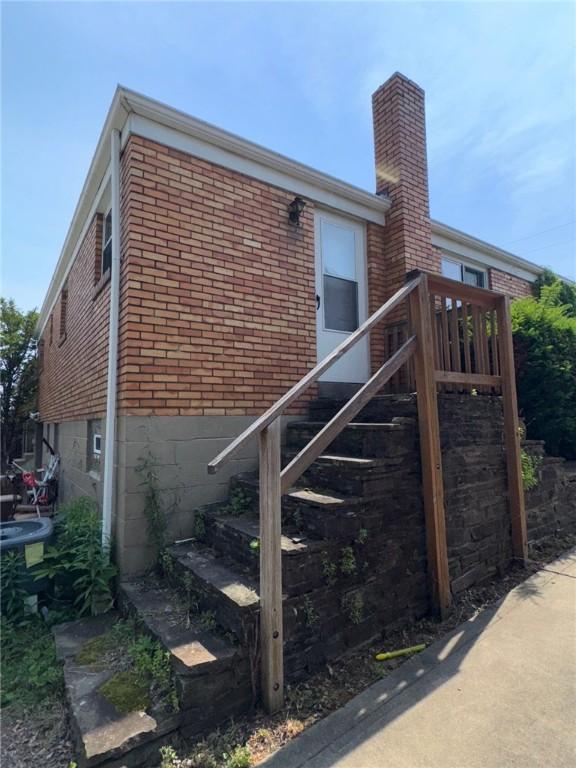 155 Roosevelt Ave, Stowe Twp, PA 15136 - view of side of property with stairway, brick siding, and a chimney