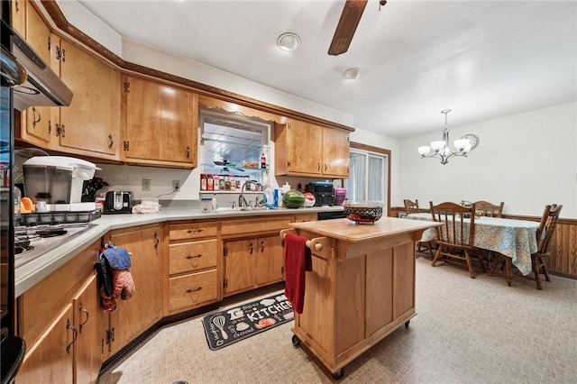 161 Thorne Dr N, Franklin Twp, PA 15301 - kitchen with under cabinet range hood, light countertops, a chandelier, hanging light fixtures, and brown cabinetry