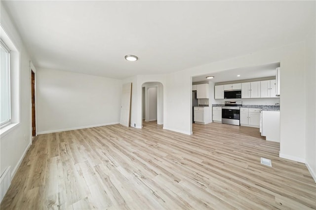 1460 Guffey Rd, North Huntingdon, PA 15642 - unfurnished living room with arched walkways and light wood-style flooring