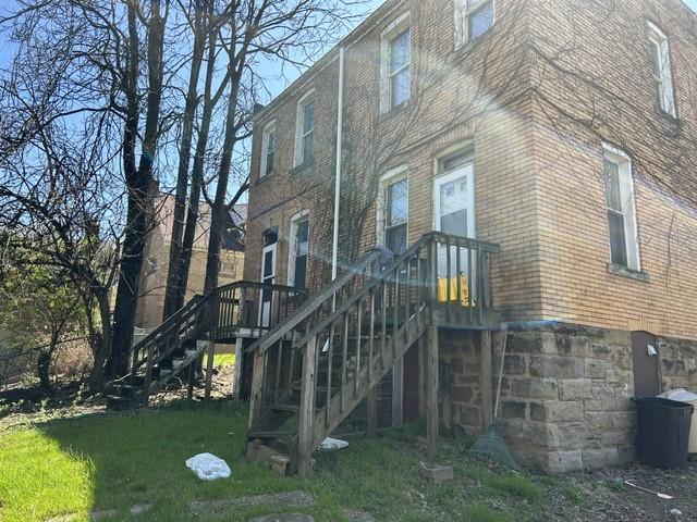 3134-3136 Huxley St, Sheraden, PA 15204 - rear view of house featuring stairs, brick siding, and a lawn