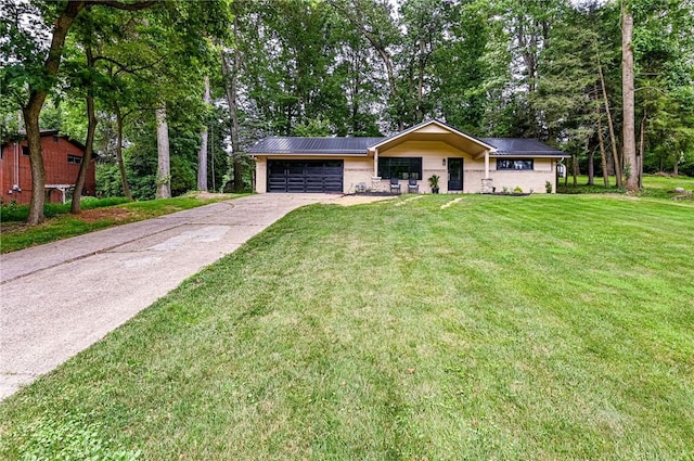 5 Bel Aire Dr, Murrysville, PA 15626 - view of front facade featuring a garage, concrete driveway, a front yard, a metal roof, and view of scattered trees